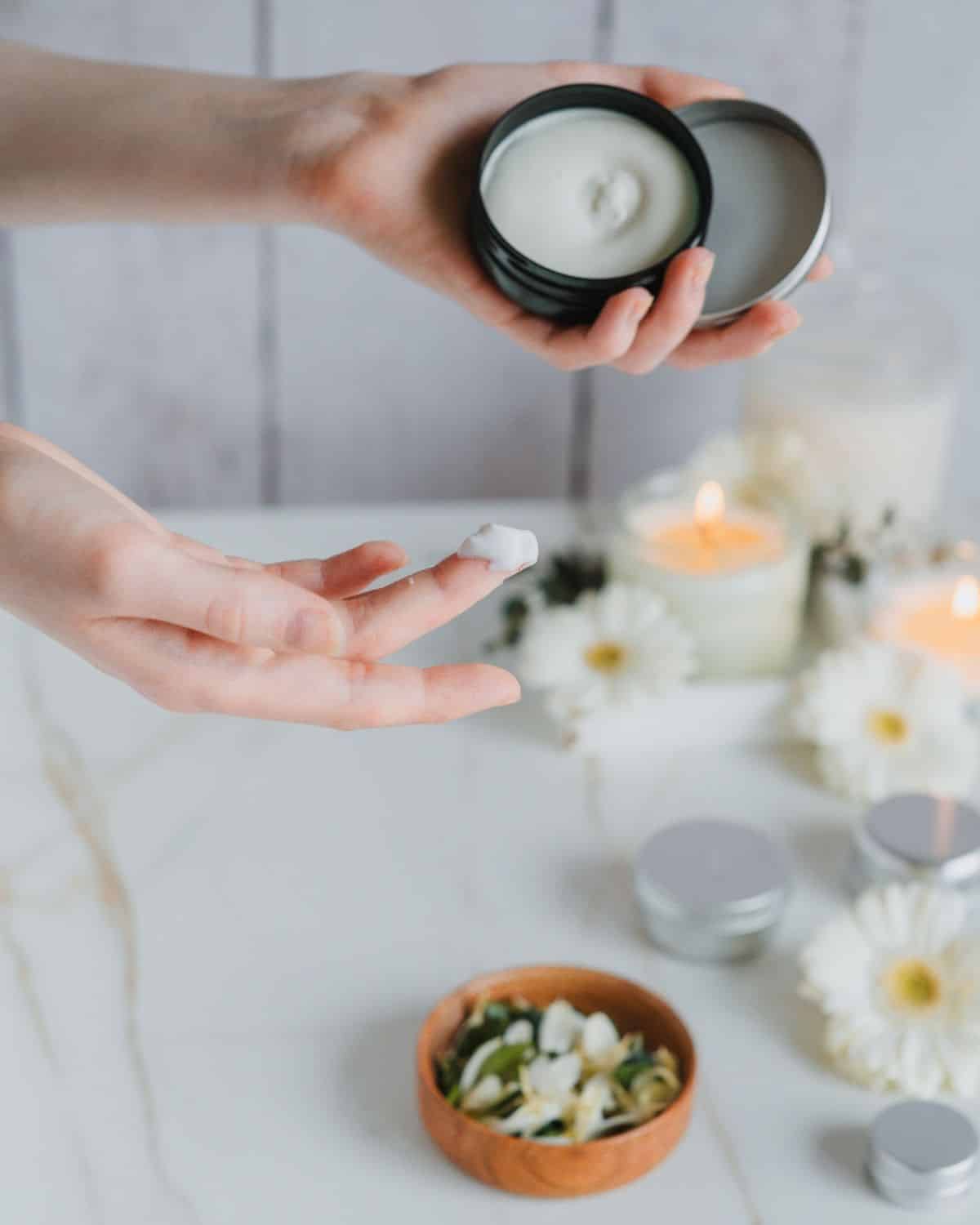  Ein Tiegel luxuriöser Körpercreme, der Hautfeuchtigkeit und -nahrung symbolisiert, auf einer glatten Oberfläche platziert.