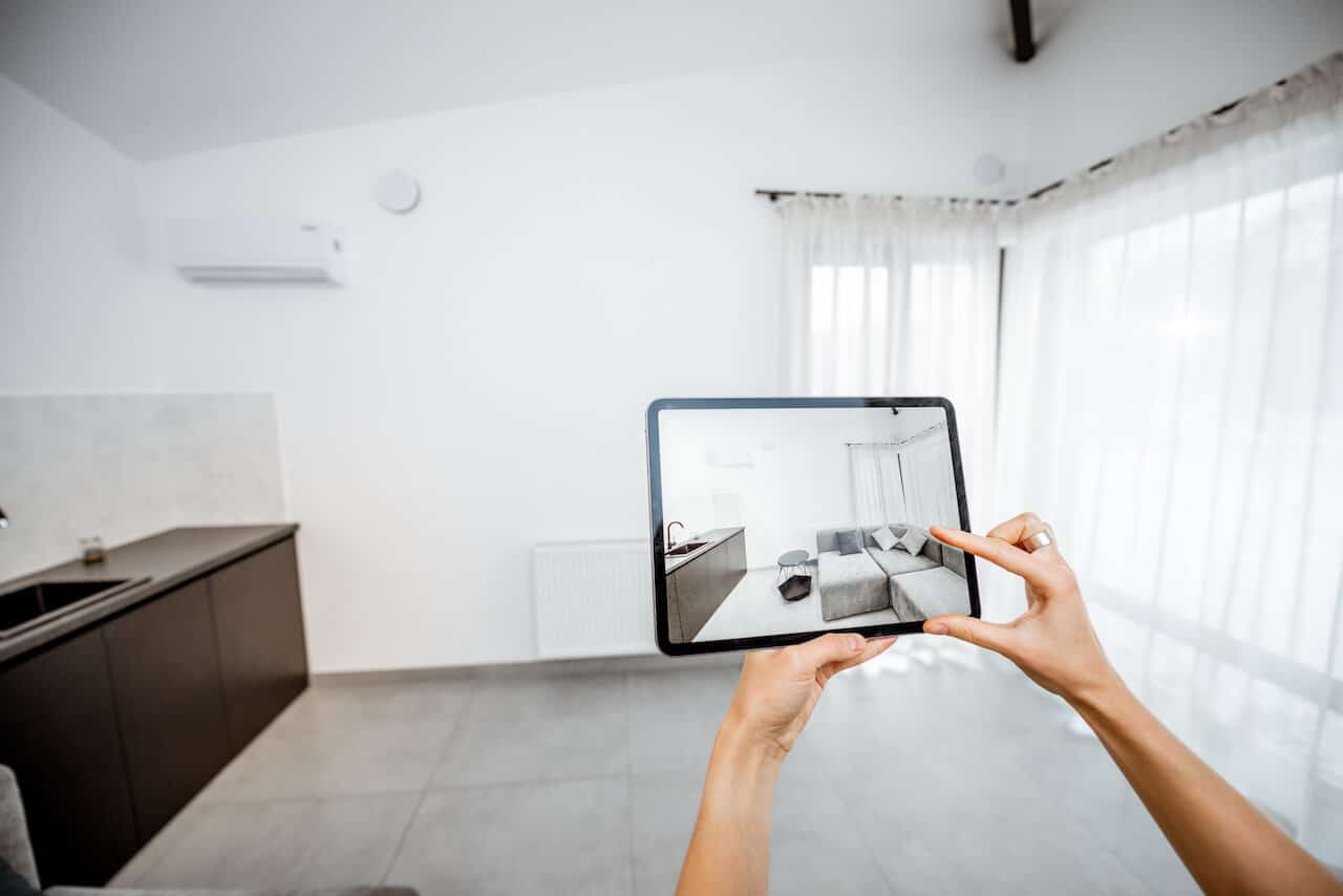 Placing new furniture on a digital tablet into the empty interior, looking how it looks before buying. Concept of augmented reality in design and retail business