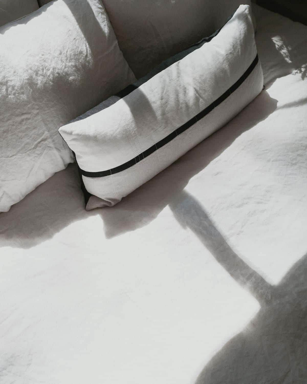 Image of a beautifully arranged bedding set, featuring a plush comforter, soft pillows, and neatly tucked sheets in a soothing color palette, suggesting a comfortable and inviting sleeping environment.