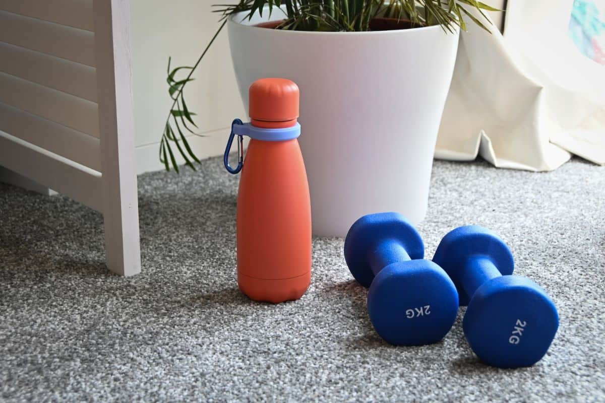 Image showing a reusable water bottle made of stainless steel with a secure lid, filled with cold, refreshing water.