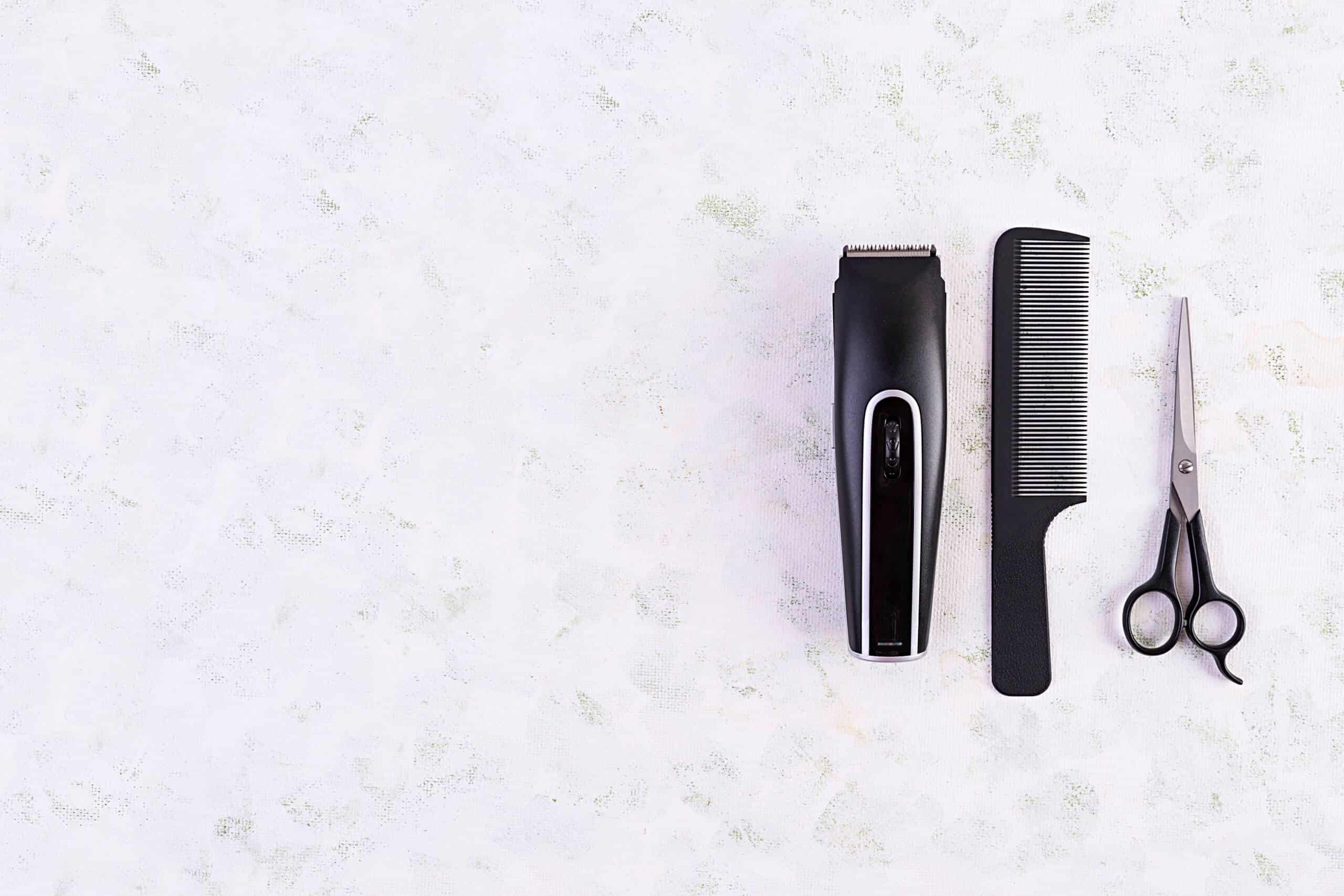 Hairdresser tools on wooden background. Haircut accessories concept. Top view