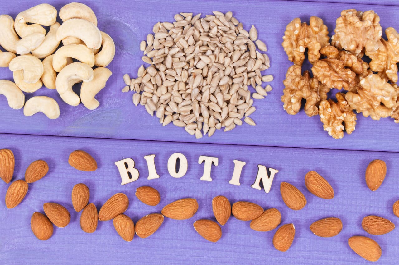 Inscription biotin with nutritious products containing vitamins and dietary fiber, natural sources of minerals, healthy nutrition concept