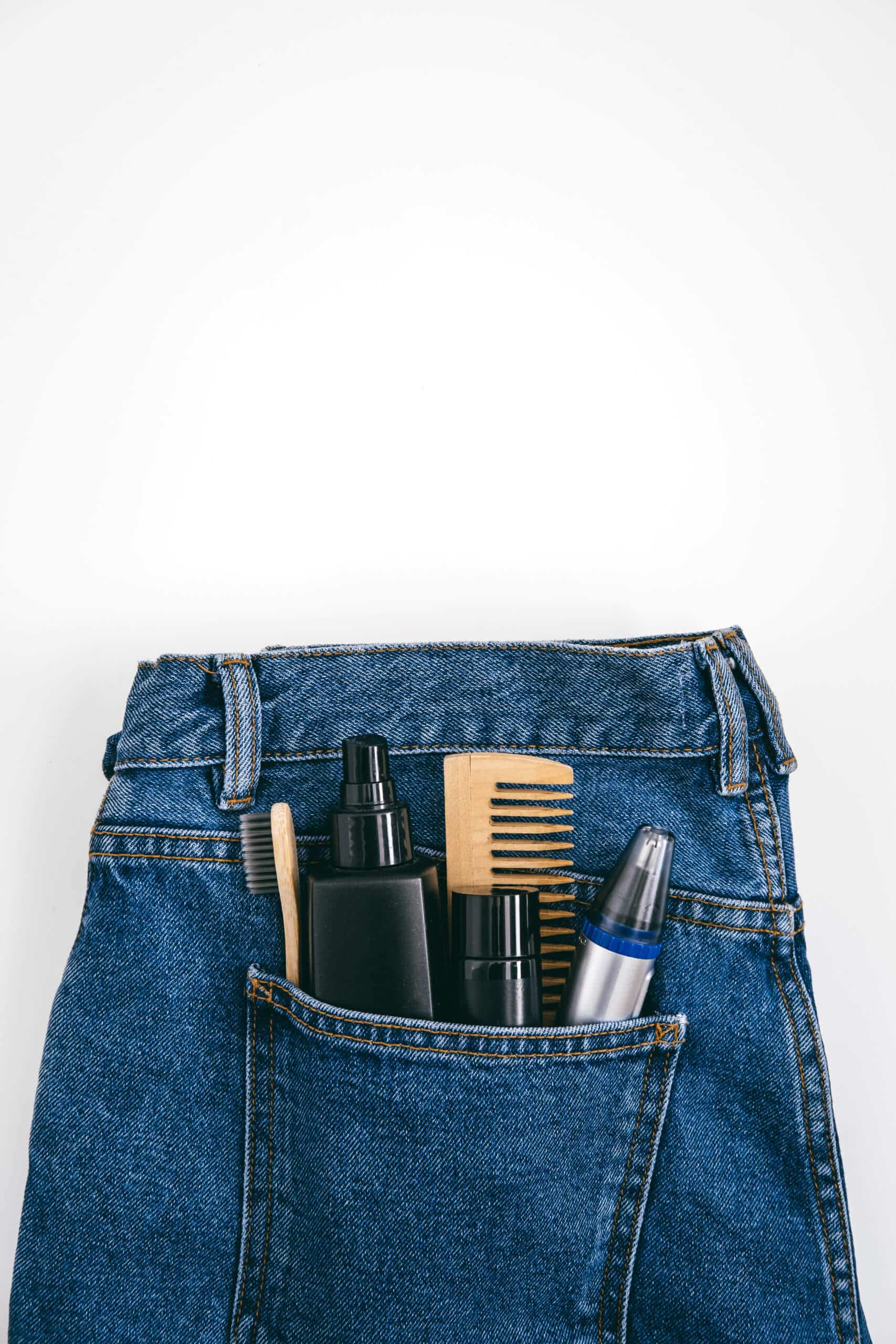 Men self care beauty kit, male beauty care cosmetic products and devices in blue jeans denim pocket. Man self care set with skin and hair care products