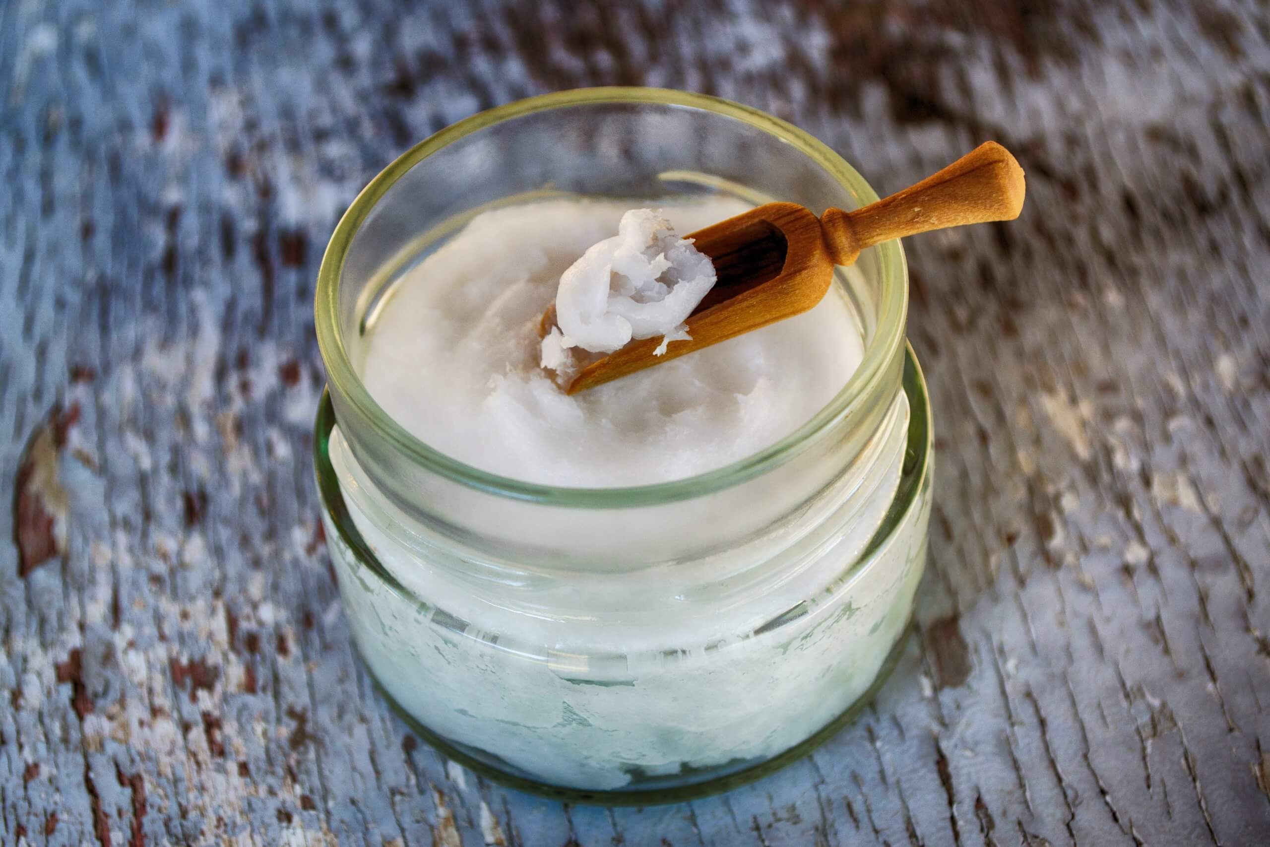 Coconut meat and coconut oil in glass bottle on coconut leaf.