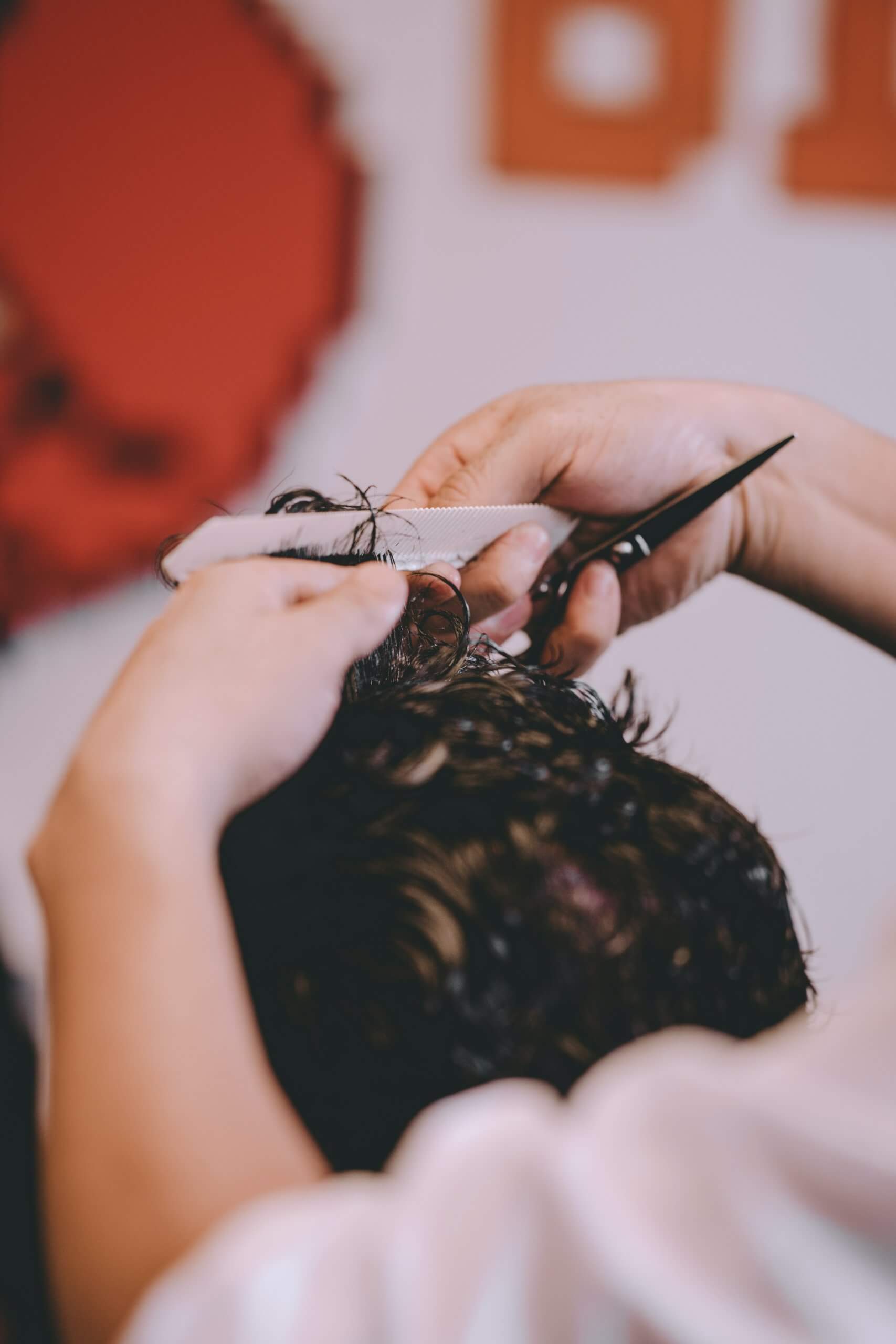 Male hairdresser cutting hair to hipster senior client while wearing face surgical mask