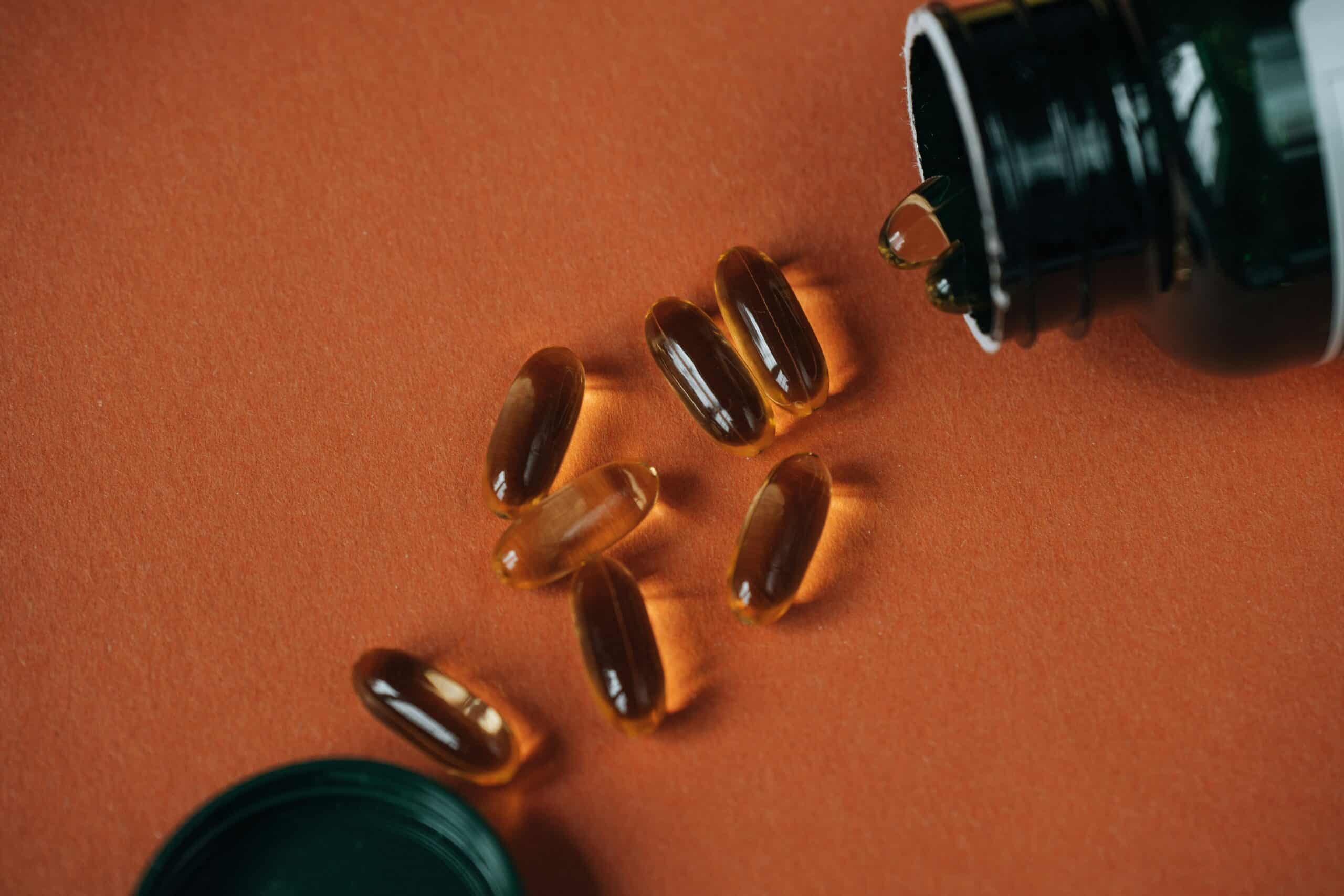 Nahrungsergänzungsmittel aus der Nähe - Vitamine fallen aus einer Flasche.