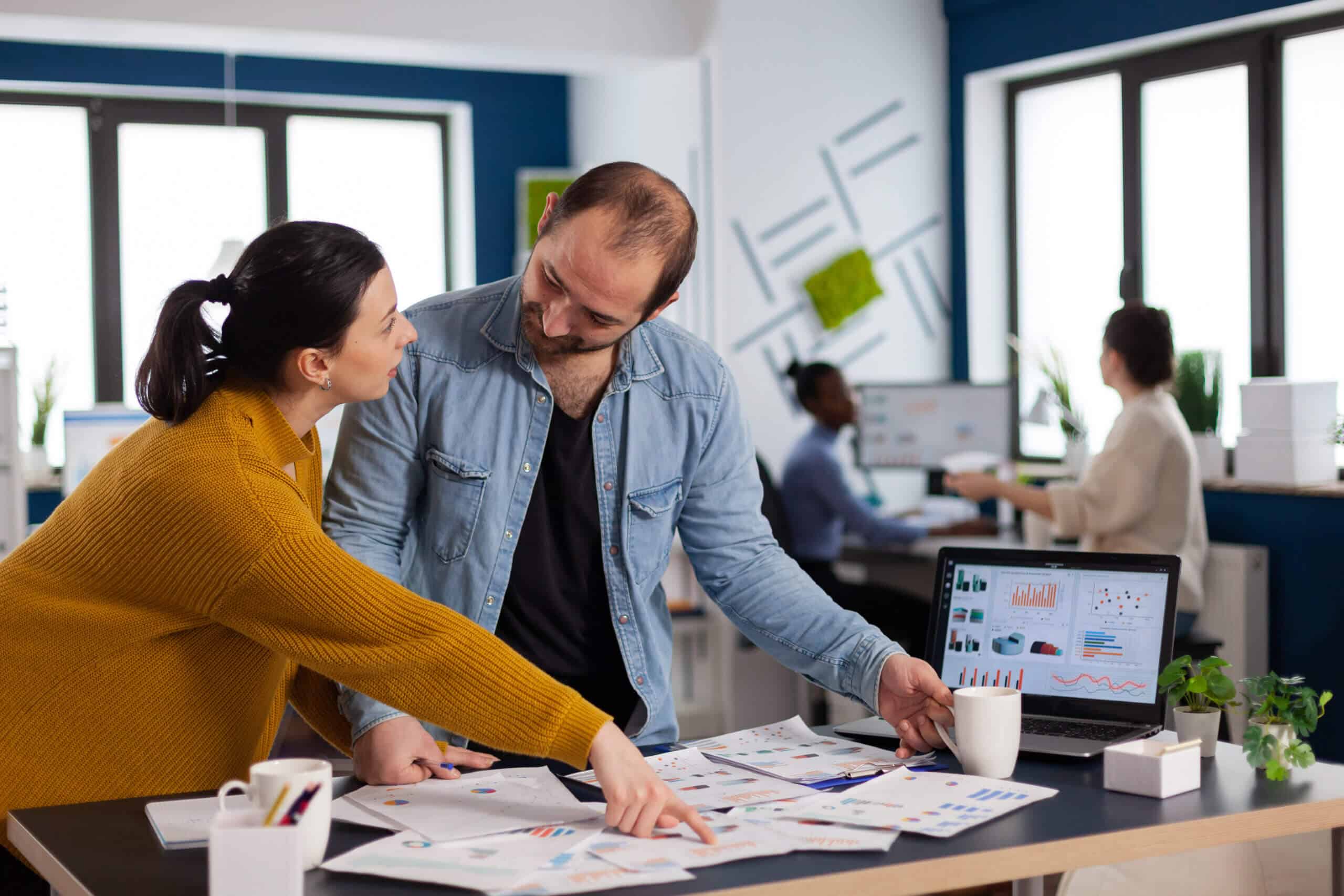 Brand manager asking for explication from employee in start up office discussion, Diverse team of business people analyzing company financial reports from computer.