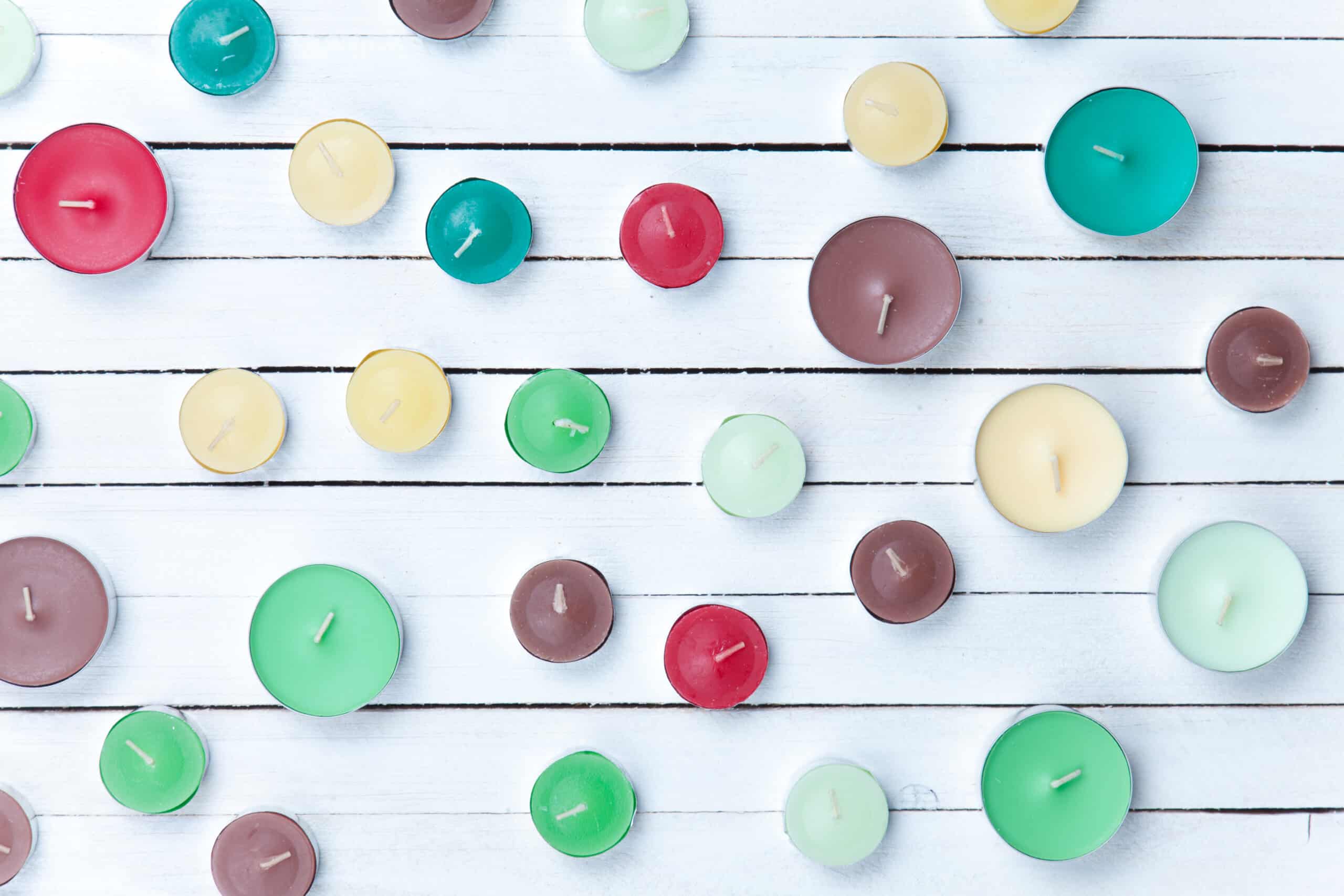Color candles on white wooden background