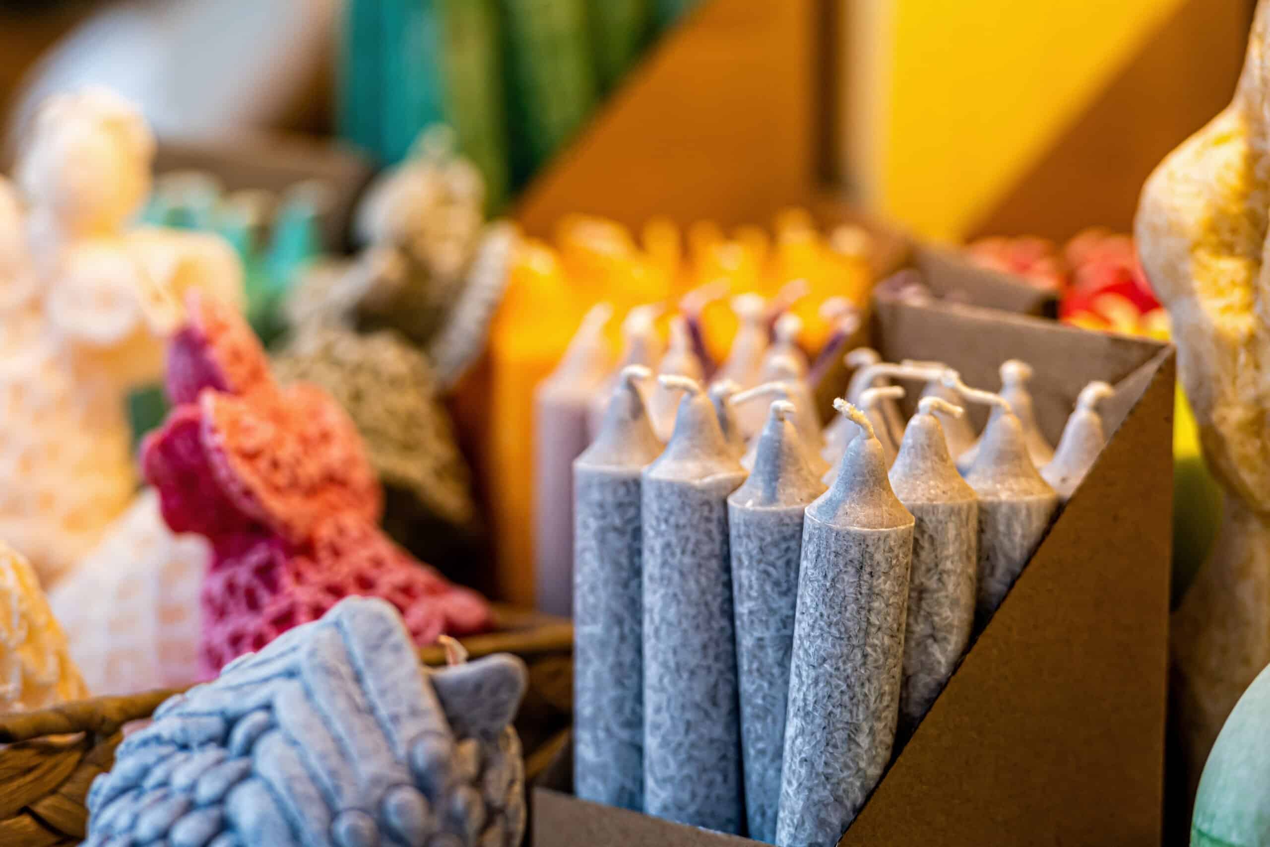 different colors and shapes of candles on the Christmas market, close-up, soft focus