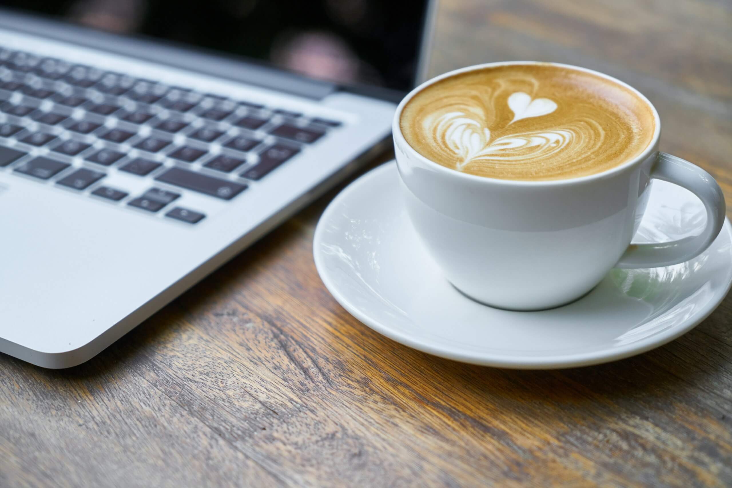 Tasse Kaffee und ein Laptop, Kaffee vs. Matcha für deine Private-Label-Bohnen