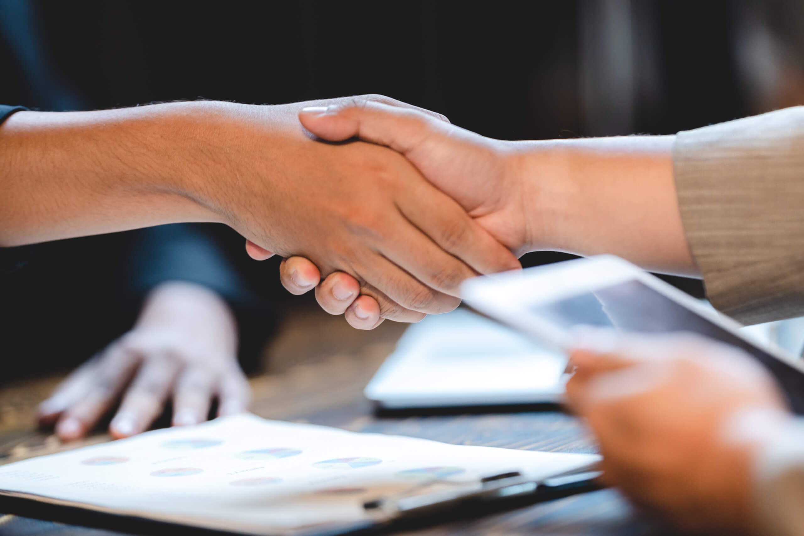 Professionelles Geschäftsteam bei einem Meeting und Brainstorming in einem modernen Büro, sie diskutieren die ISO 9001-Zertifizierung und nutzen Laptops zur Kommunikation.