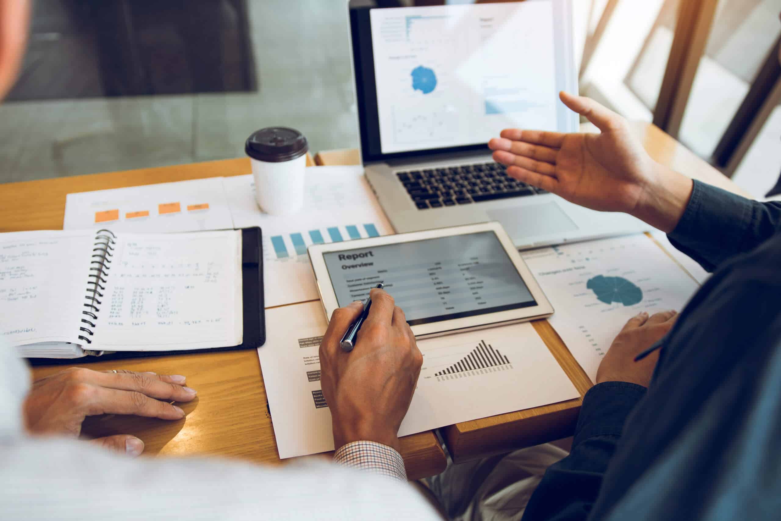 Geschäftspartner im Büro analysieren Kosten, Arbeitsfortschritt und nutzen ein Tablet für den Finanzbudgetbericht des Unternehmens und die Zukunftsplanung.