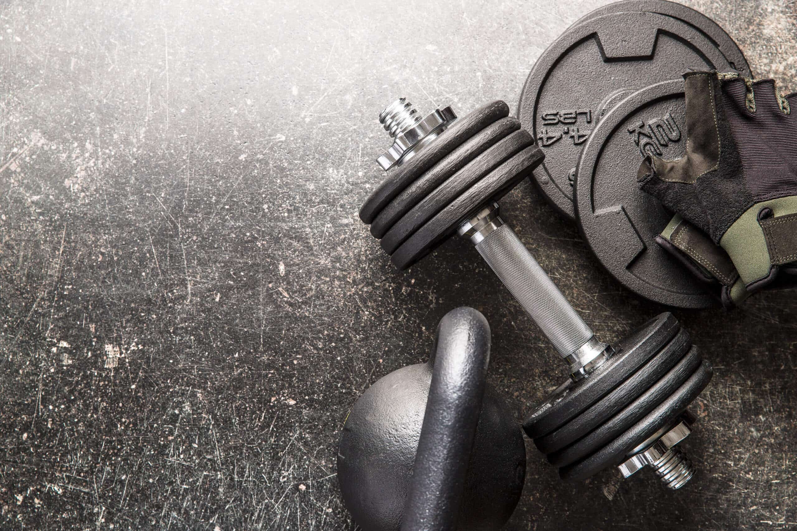 Private-Label-Fitness-Marke Hantel und Fitnesshandschuhe auf Grunge-Hintergrund.