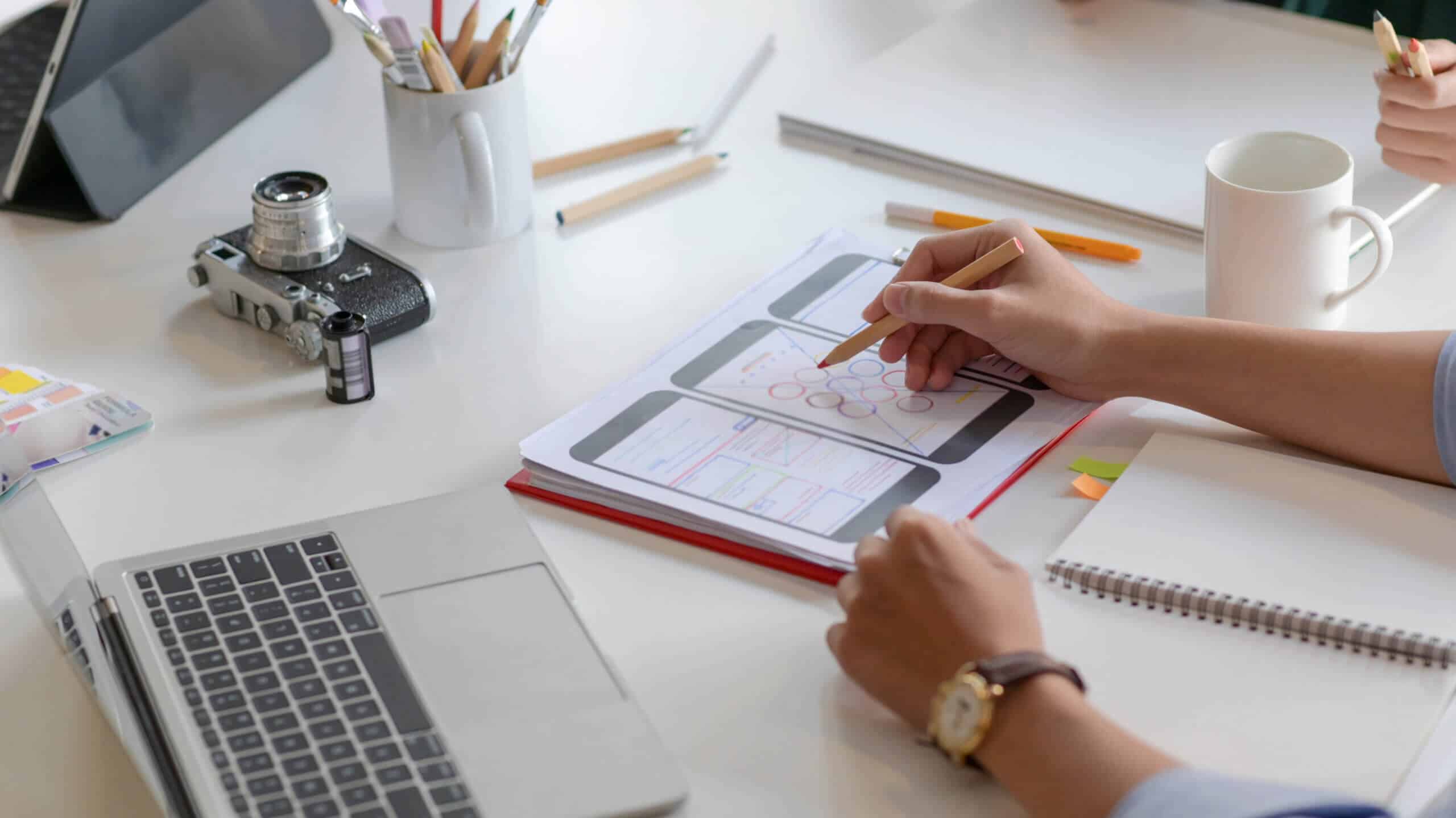 Nahaufnahme von Smartphone-App-Designern, die neue Projekte entwerfen, um Kunden eine Produkthaftpflichtversicherung zu zeigen
