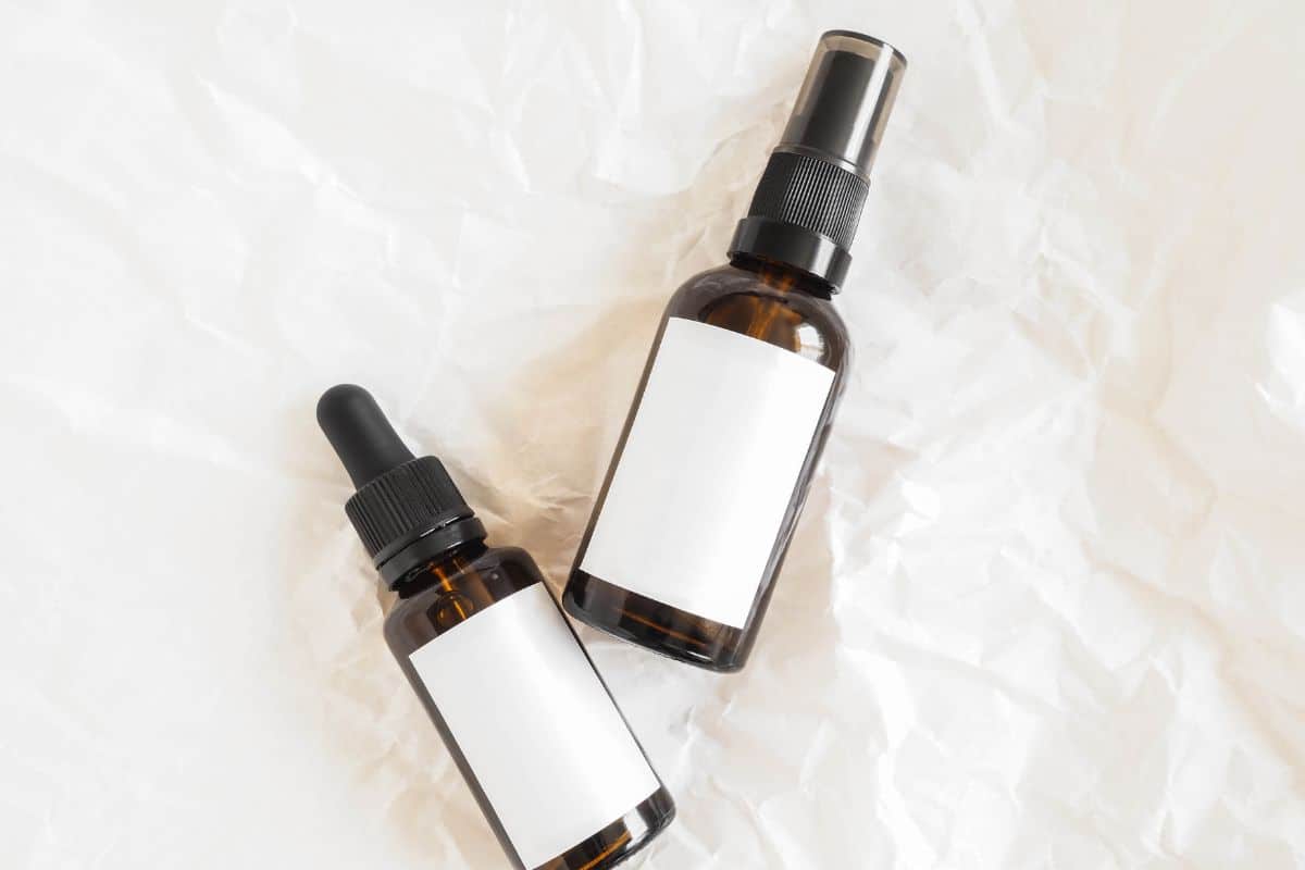A small vial of golden face oil sample, displayed against a neutral backdrop, offering a glimpse into the product’s nourishing qualities for potential skincare enthusiasts.