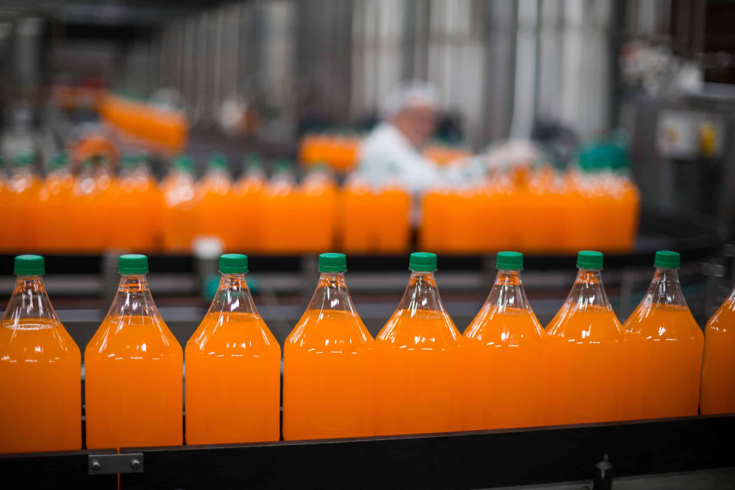 Flasche mit Saft wird in einer Flaschenfabrik auf der Produktionslinie verarbeitet