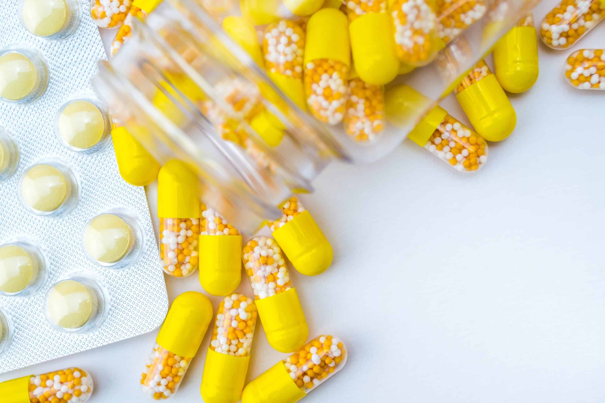 Woman's hands sorting pills into pills organizer. Close up medical pill box with daily doses of medicines. Antioxidant diet vitamin supplements for health and beauty care, biohacking concept