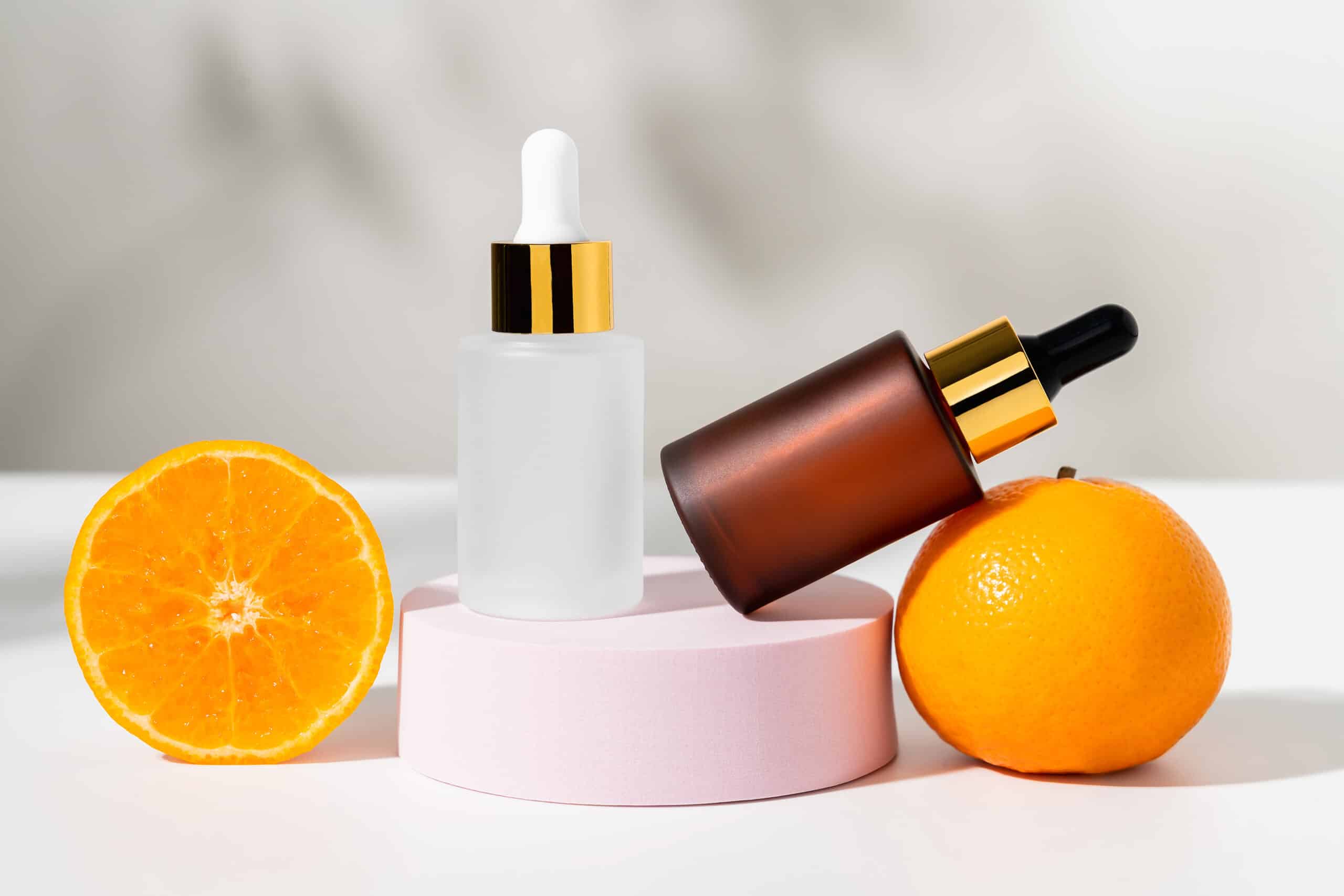 Serum bottle with dropper and slice of orange, ingredients for skin care and treatment vitamin on white background, Natural cosmetics concept.