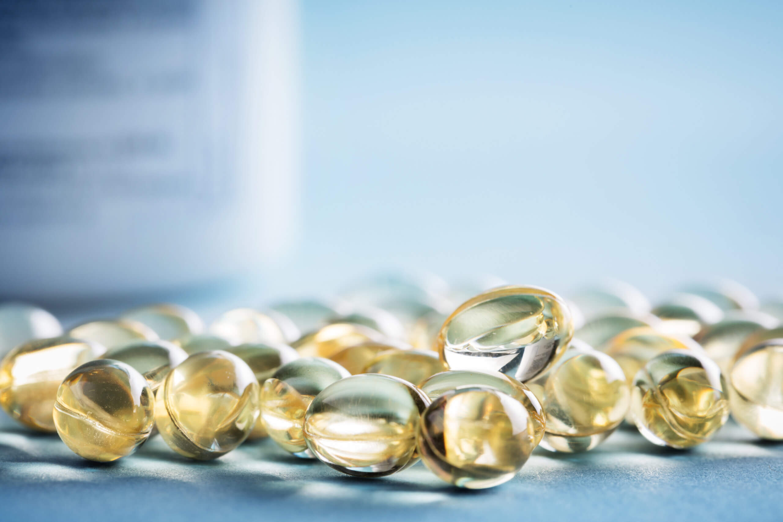 Vitamin D laying on the table with prescription bottle behind them. gummy Supplement pills.