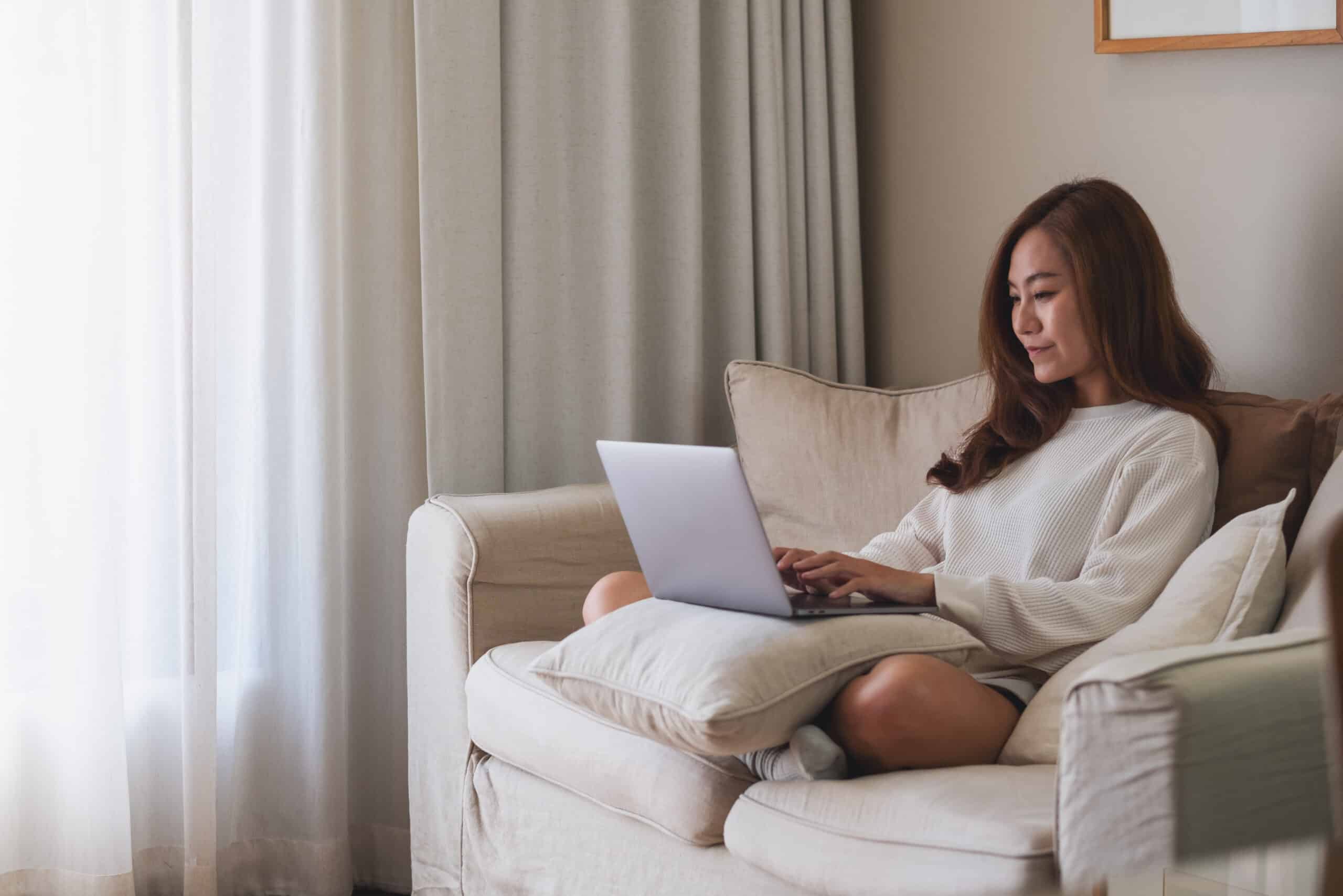 A young woman using laptop computer for working or studying online at home