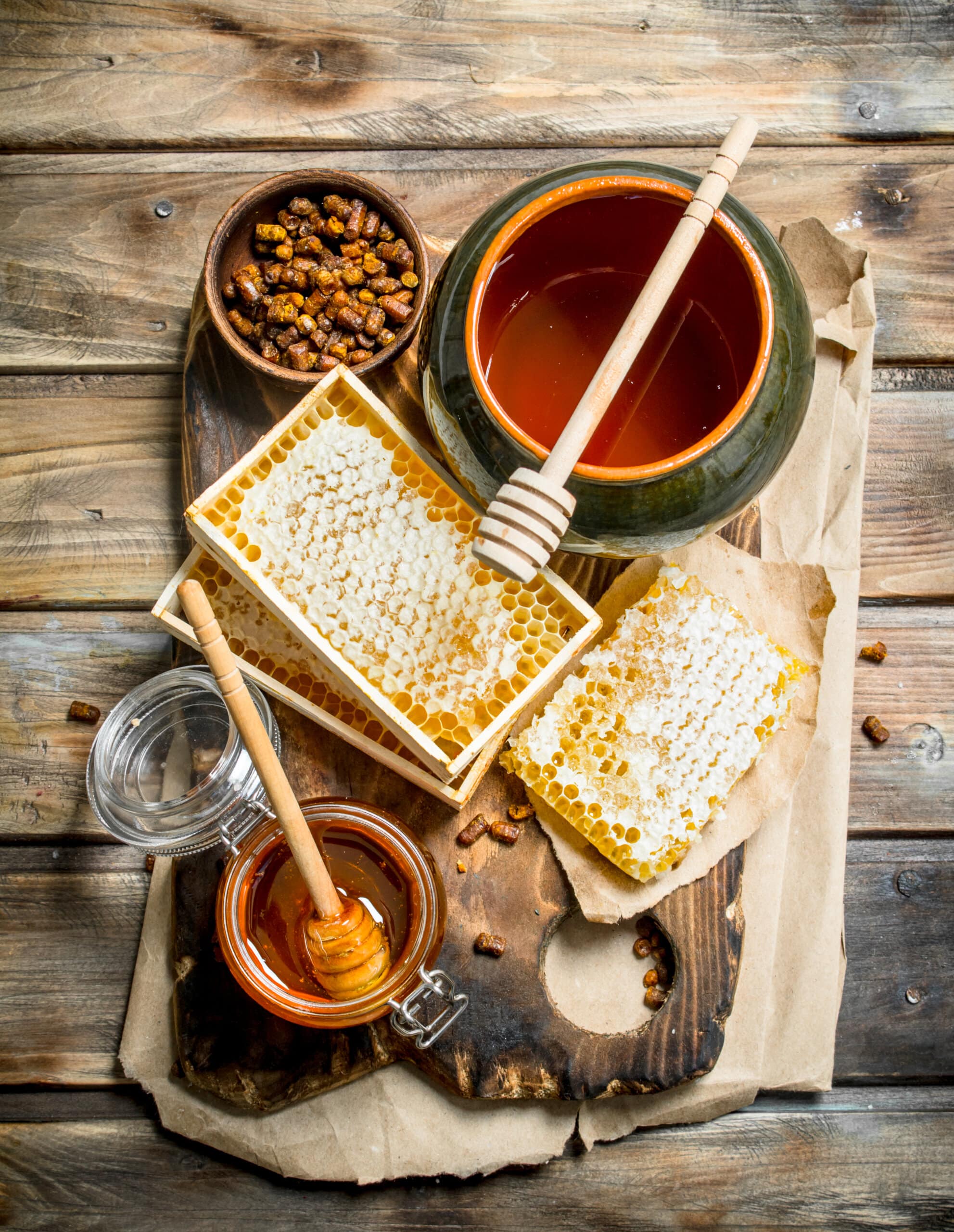 Assortment of different types of honey. On a wooden background.