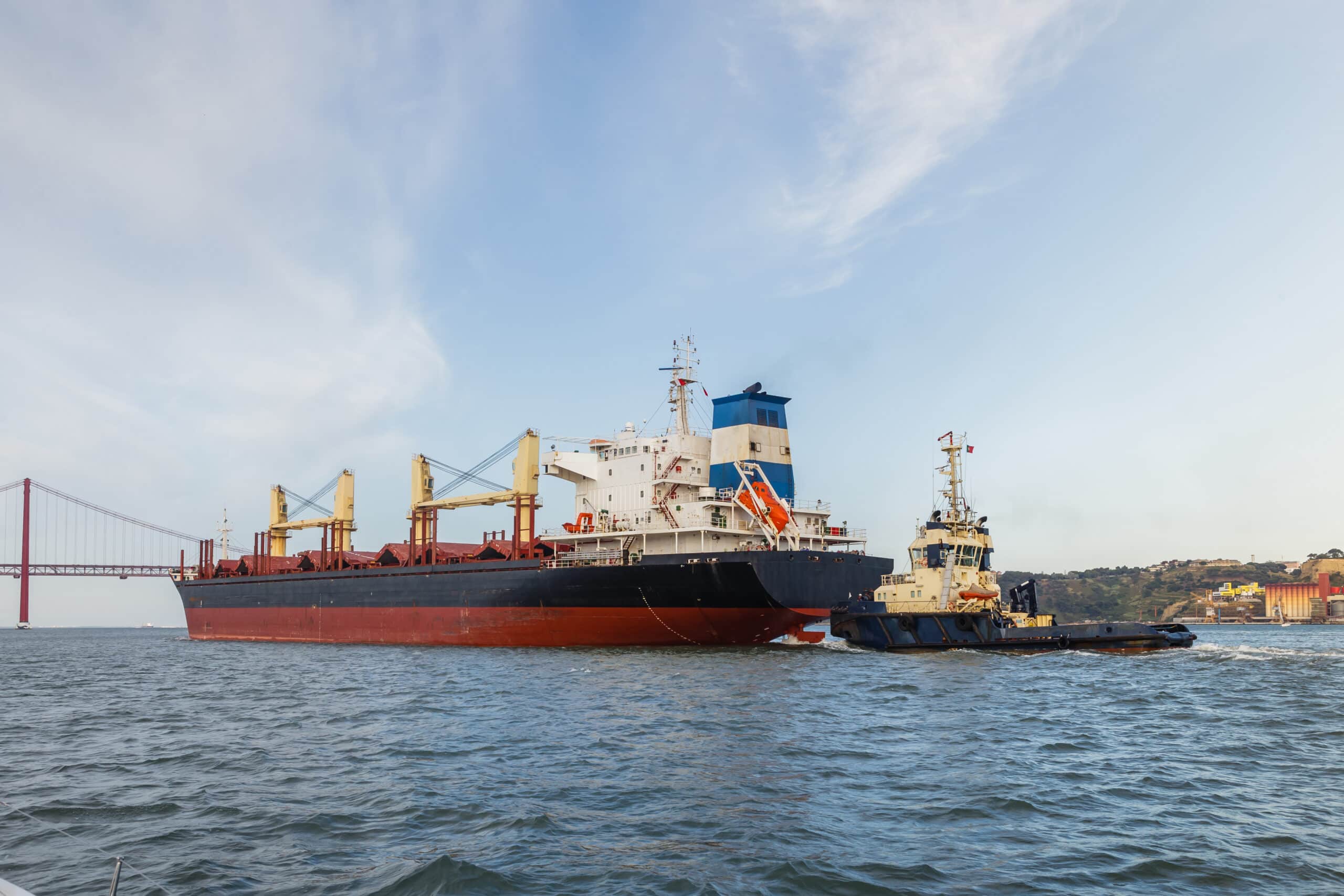 Cargo ships in river being tugged