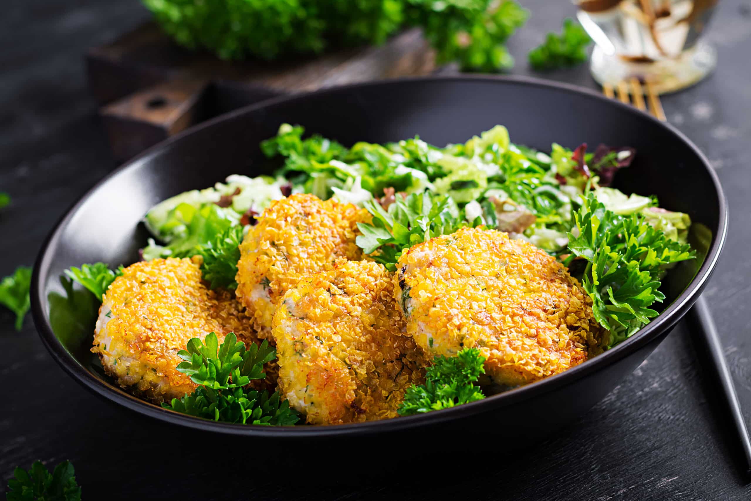 Homemade fish croquettes from white fish in cornflakes breading. Fritters from minced cod. Delicious and nutritious lunch or dinner.