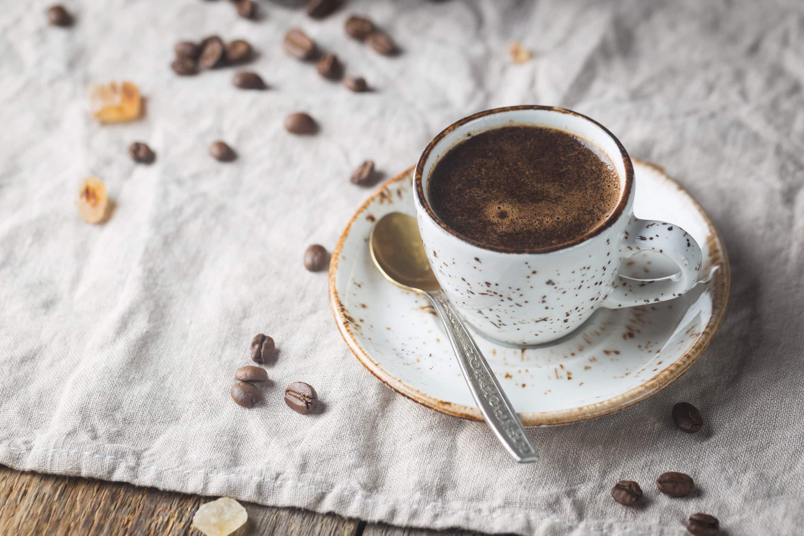 Hot Coffee cup and coffee beans on the wooden table, rustic style