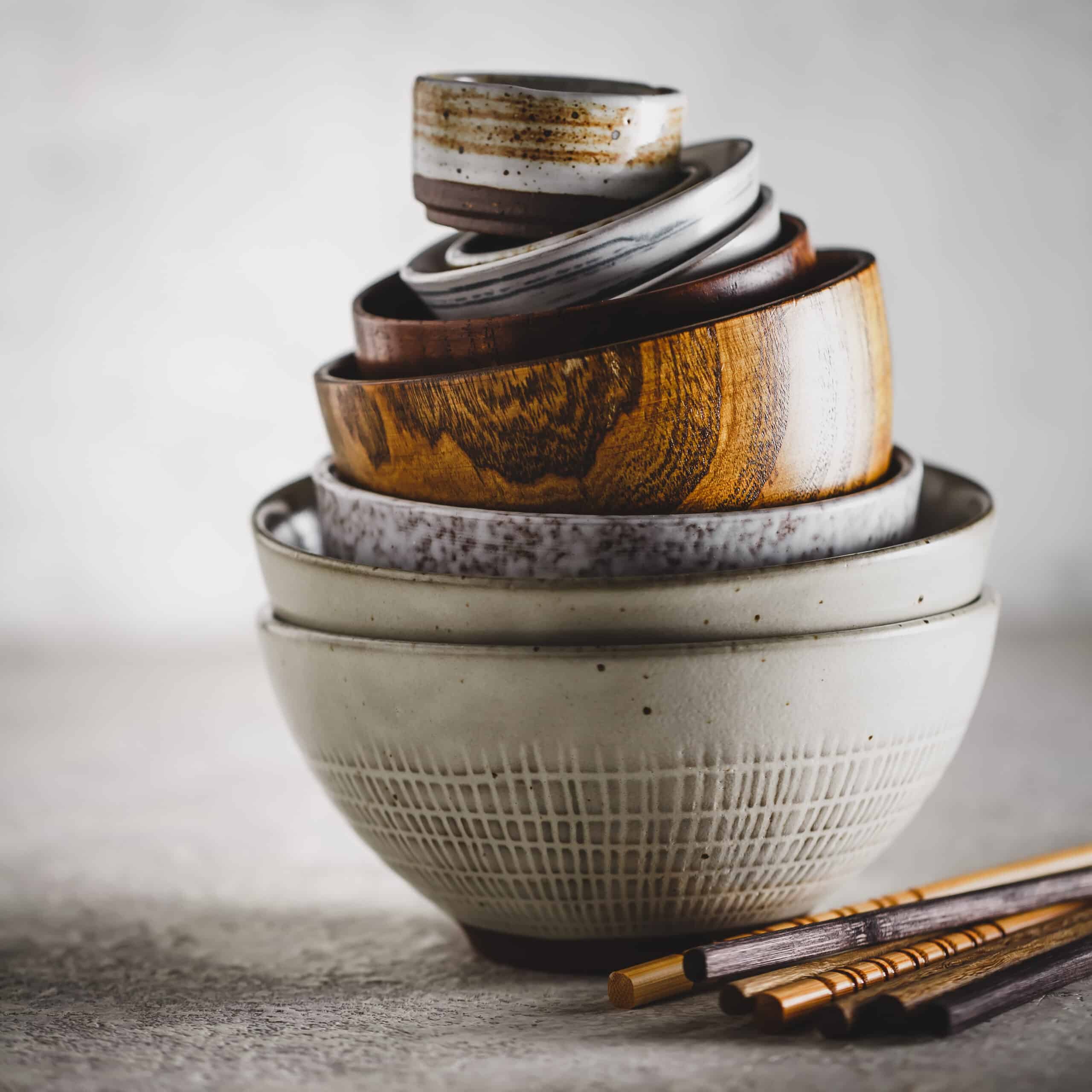 Ceramic and wooden bowls stacked together. Oriental style.