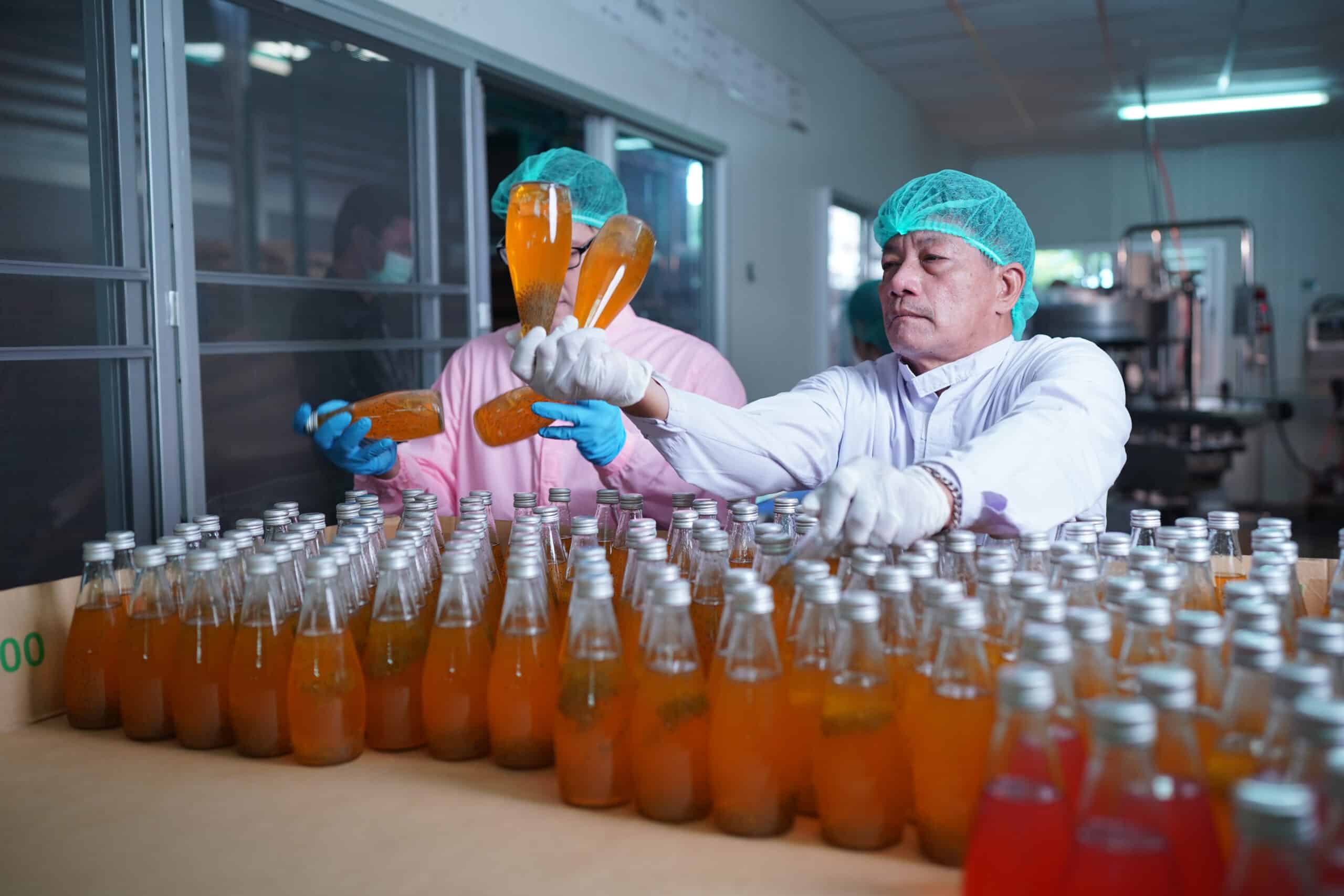 Arbeiter kontrolliert die Arbeit der Maschine in der Produktionslinie in der Getränkeindustrie.