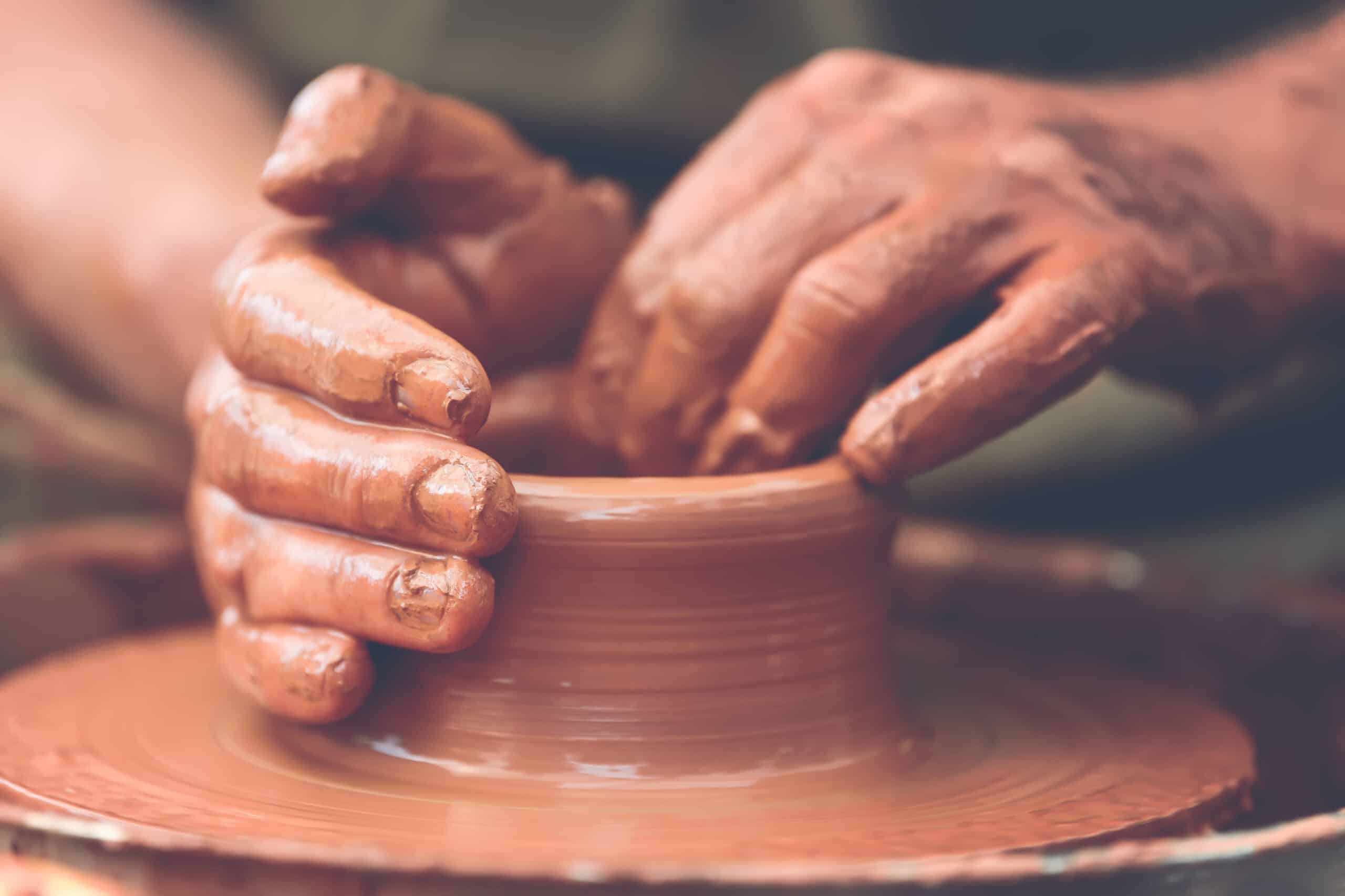 Hands of a potter. Potter making ceramic pot on the pottery wheel