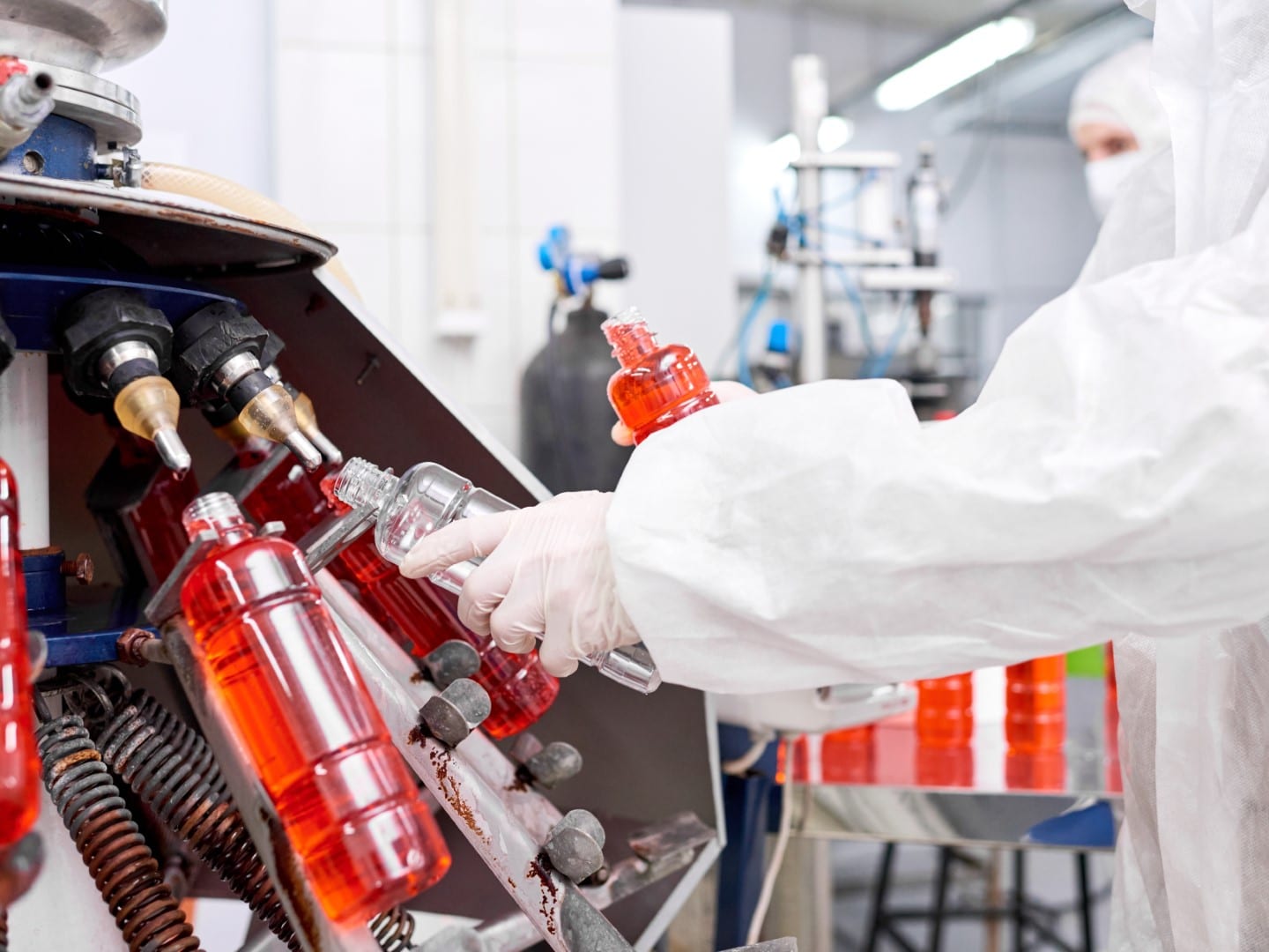 Ein Foto, das den Lohnfertigungsprozess zeigt, bei dem Arbeiter in einer gut beleuchteten Fabrik Produkte an einem Fließband montieren.