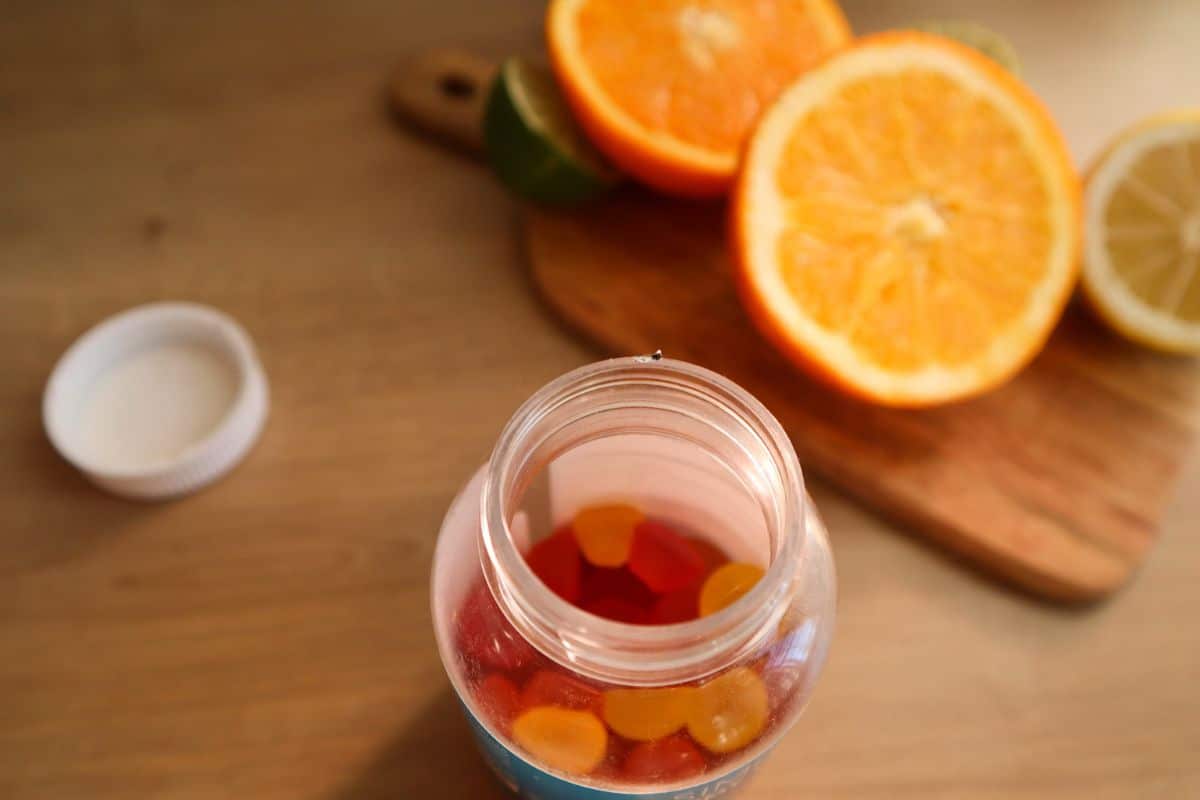 Helle und farbenfrohe Vitamin-Gummibärchen in verschiedenen Formen, auf einem einfachen Hintergrund ausgelegt, die eine unterhaltsame Art der Vitamineinnahme zeigen.