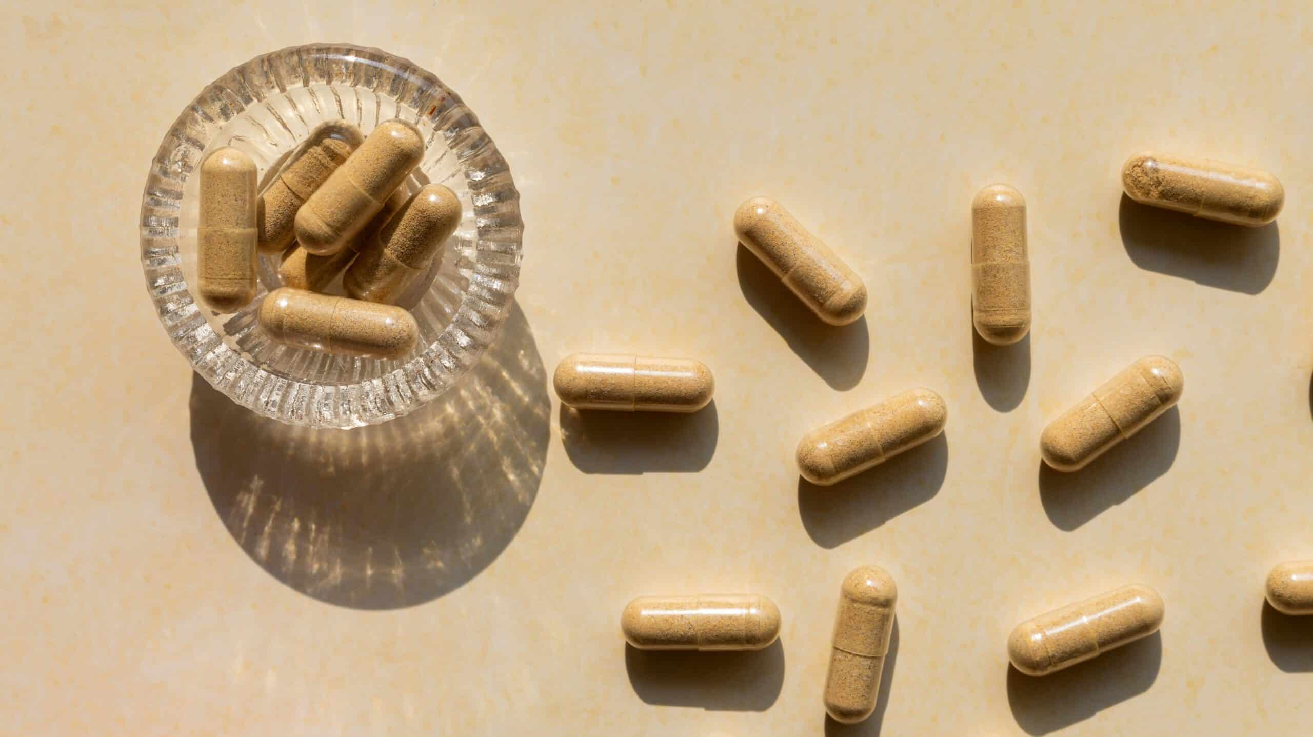 Contract Manufacturers for Supplements: A photo of pills in a small glass holder on a table.