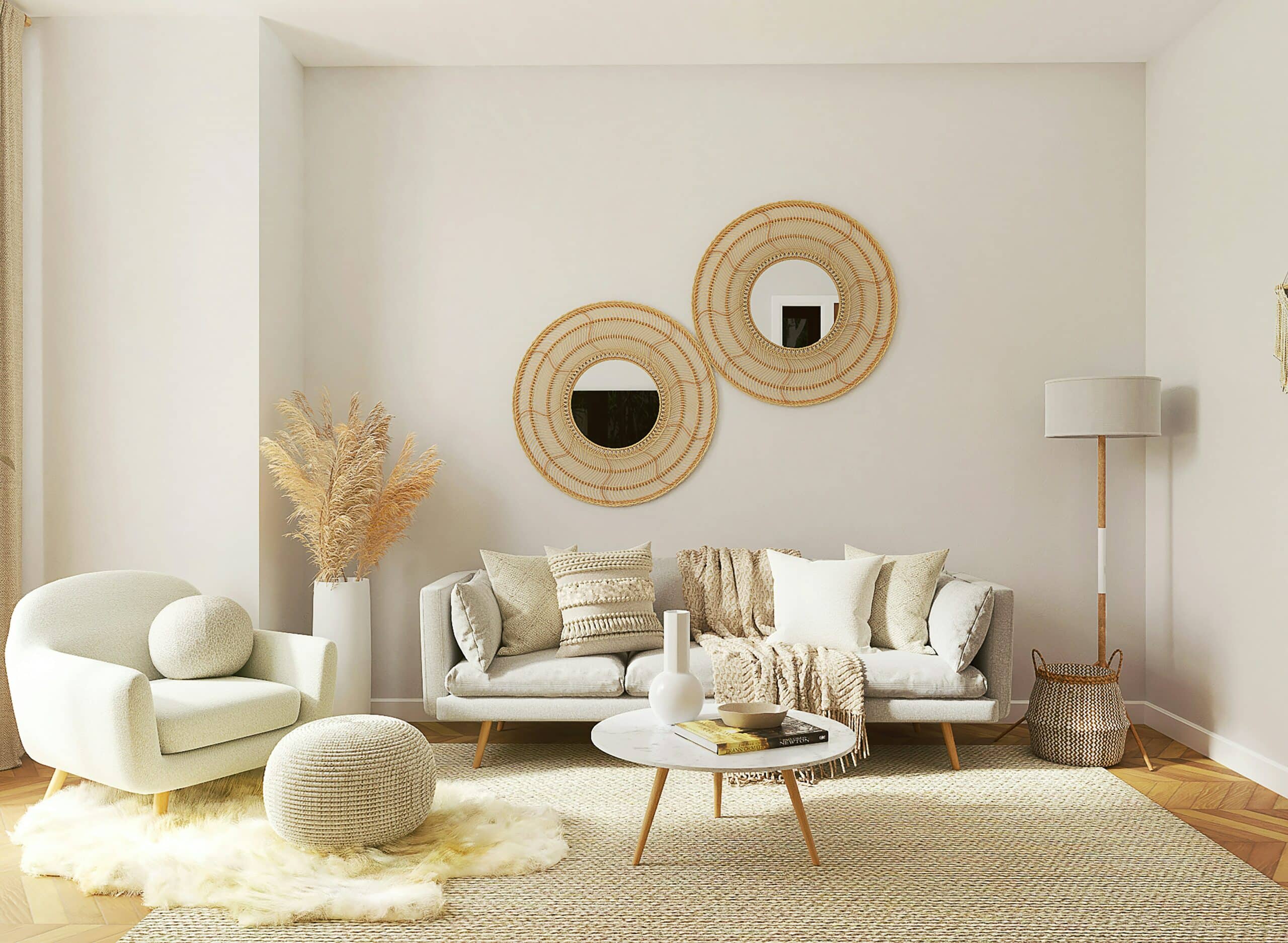 A living room with light cream and white furniture such as a chair, couch, led rest, coffee table, and rugs. A mirror is positioned on the wall behind the couch, with faux plants to the side.