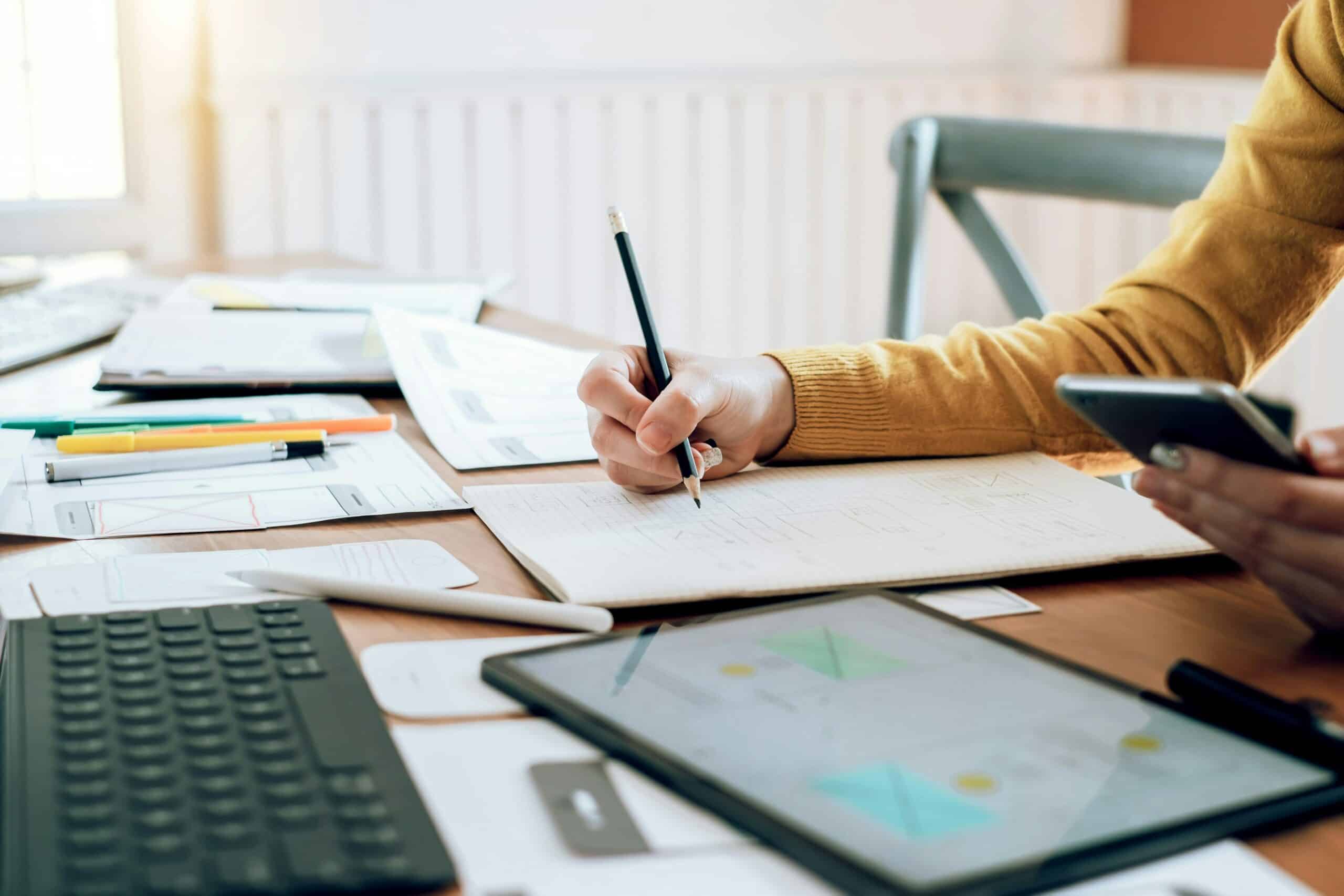 A person researching and writing down notes.