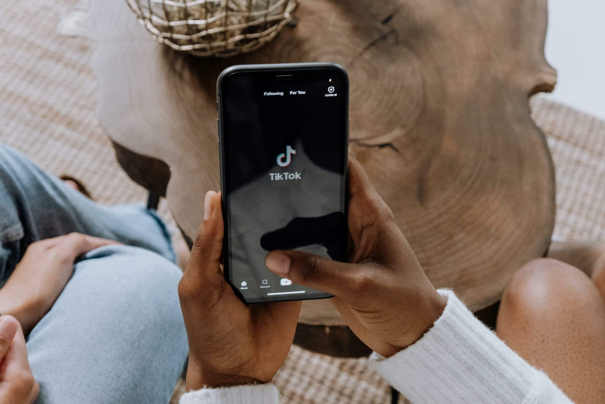 Person öffnet die TikTok-App auf ihrem Mobilgerät.